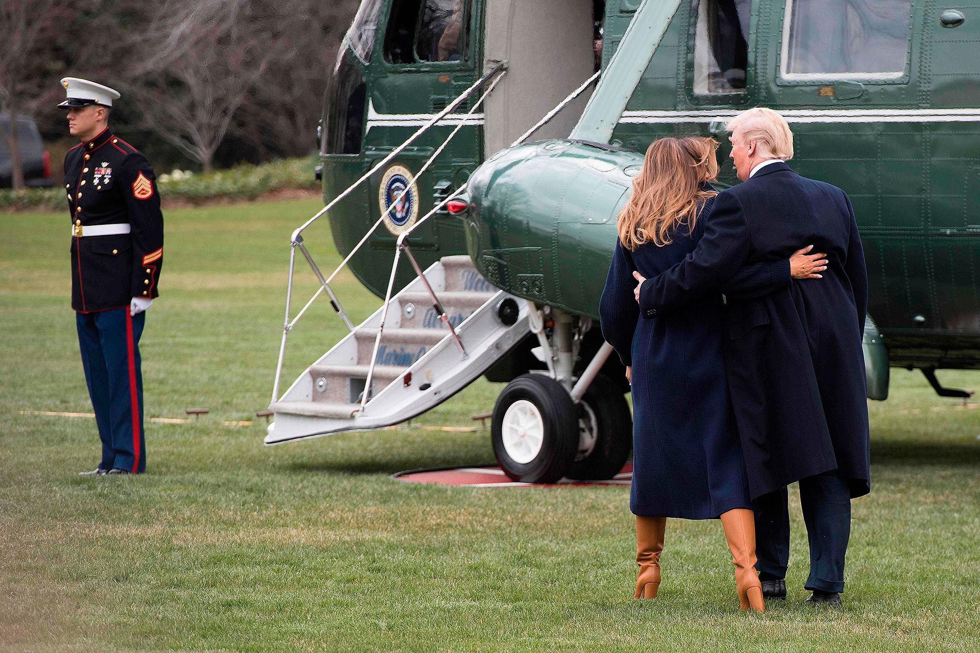 President Donald Trump and First Lady Melania Trump with their arms around each other heading toward Marine One